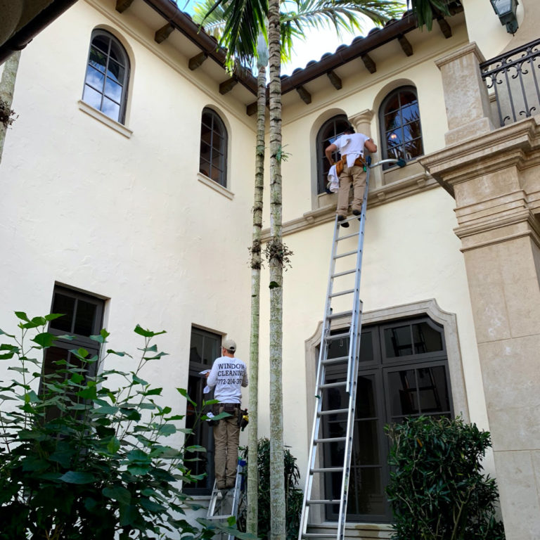 Window cleaner in palm city on a ladder