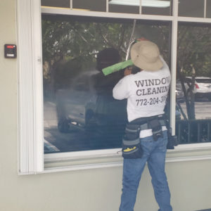 Window cleaner cleaning dirty windows
