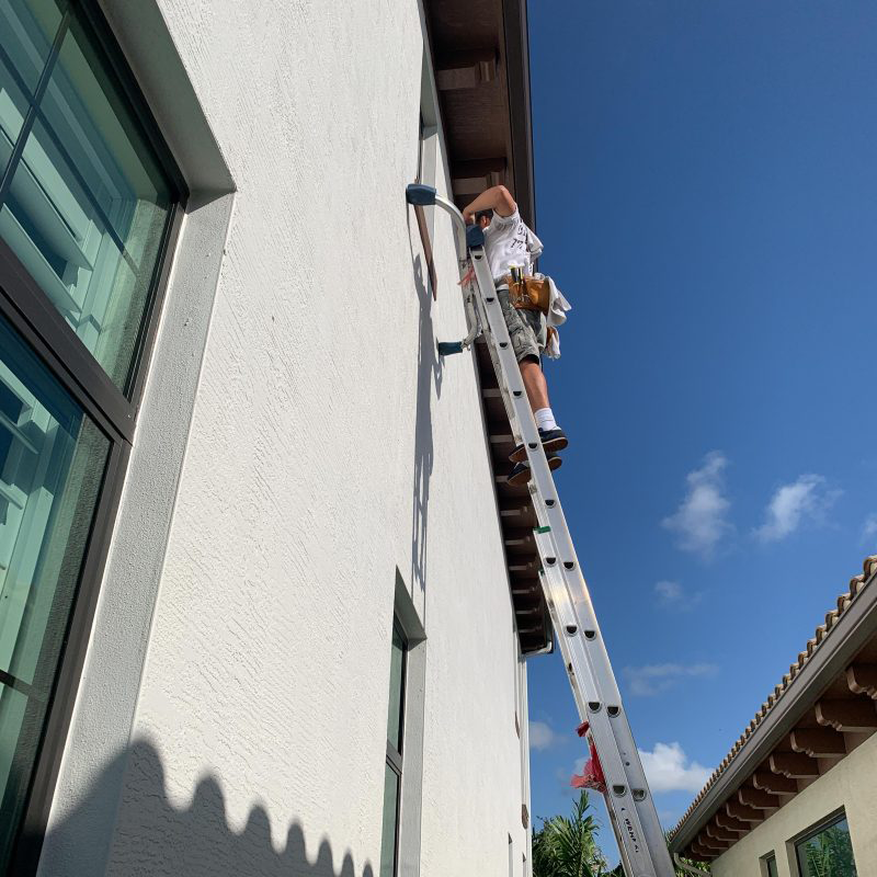 Olaf's window cleaning tech meticulously cleaning windows - Jupiter Island